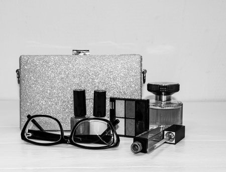 Glittery silver clutch bag with beauty products isolated on white background with copy space.の写真素材