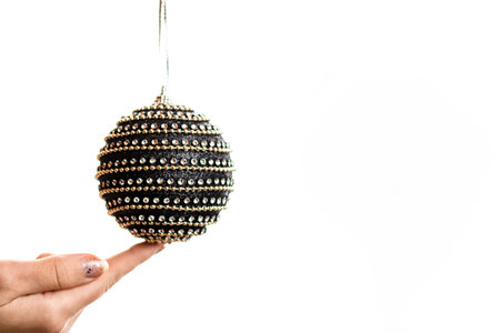 Hand holding showing giving or receiving Christmas bauble decoration isolated on white backgroundの写真素材