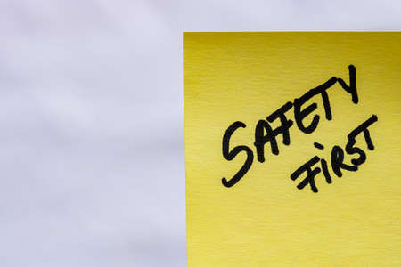 Safety first handwriting text close up isolated on yellow paper with copy space.の写真素材