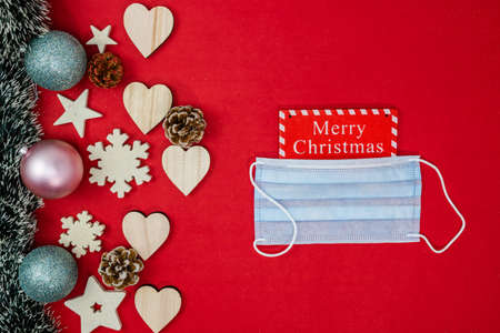Surgical mask in Christmas composition. Decorated Christmas background with christmassy ornaments and decorations. Top view with copy space.の写真素材