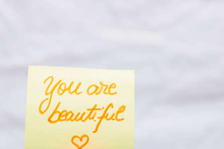 You are beautiful handwriting text close up isolated on yellow paper with copy space.の写真素材