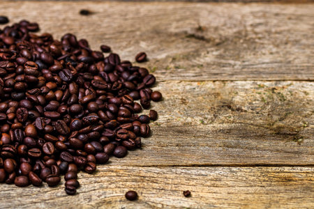 Roasted coffee beans isolated on wooden table.