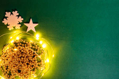 Christmas lights in a december season composition with ornaments and decorations. Top view with copy space on green background.の写真素材