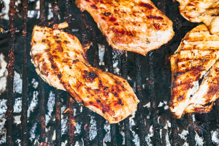 Chicken and pork steak grilled on a charcoal barbeque. Top view of camping tasty barbecue, food concept, food on grill and detail of food on the grillの写真素材