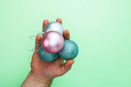 Man hands holding colorful Christmas balls. Top view with copy space for december seasonの写真素材