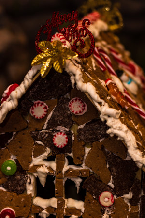 Colorful gingerbread house isolated on blurred background with Christmas decoration.
