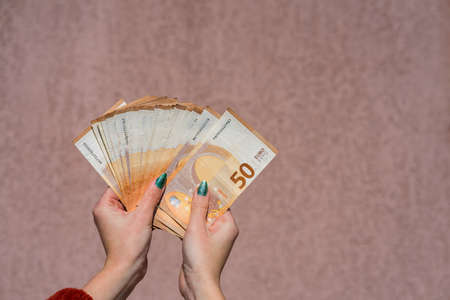 Hand holding and showing a fan of euro money or giving money. World money concept, 50 EURO banknotes EUR currency isolated. Concept of rich business people, saving or spending money.の写真素材