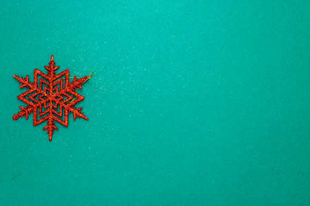 Snowflake Christmas decoration on green background. Top view with copy space for december season.の写真素材