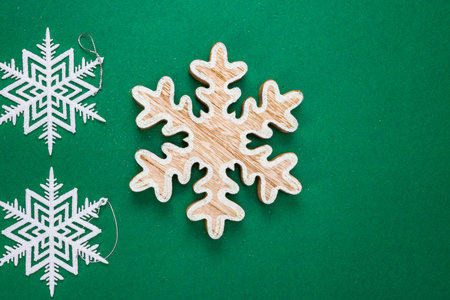 Snowflakes Christmas decoration on green background. Top view with copy space for december season.