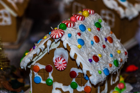 Colorful gingerbread house isolated on blurred background with Christmas decoration.の写真素材