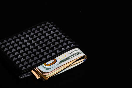 Dollars money banknotes in a black wallet isolated.の写真素材