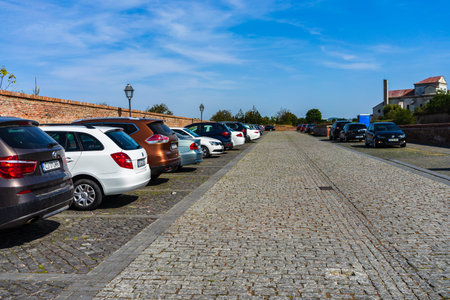Parked cars along a cobblestone street in Alba Iulia, Romania, 2020.