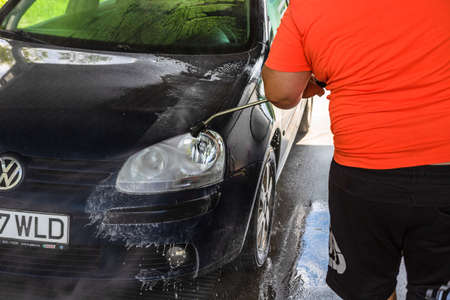 Washing and cleaning car in self service car wash station. Car washing using high pressure water in Bucharest, Romania, 2021のeditorial素材
