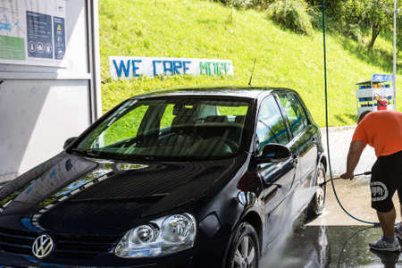 Washing and cleaning car in self service car wash station. Car washing using high pressure water in Bucharest, Romania, 2021のeditorial素材
