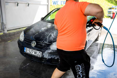 Washing and cleaning car in self service car wash station. Car washing using high pressure water in Bucharest, Romania, 2021のeditorial素材