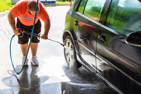Washing and cleaning car in self service car wash station. Car washing using high pressure water in Bucharest, Romania, 2021のeditorial素材