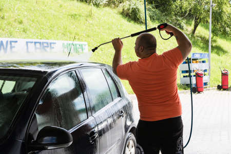 Washing and cleaning car in self service car wash station. Car washing using high pressure water in Bucharest, Romania, 2021のeditorial素材