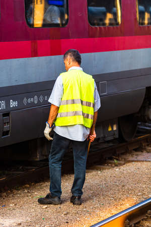 Train crew man doing checkings on the platform at the Bucharest North Railway Station in Bucharest, Romania, 2020のeditorial素材