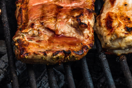 Close up of pork steak grilled on a charcoal barbeque isolated.