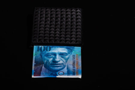 100 swiss franc banknote in a black wallet isolated.