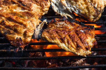 Grilled mackerel fish with smoke on a charcoal barbecue grill.の写真素材