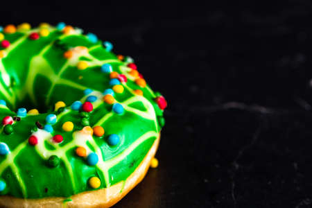 Green glazed donut with sprinkles isolated. Close up of colorful donut.の写真素材