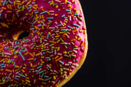 Pink glazed donut with sprinkles isolated. Close up of colorful donut.の写真素材