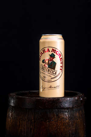 Can of Birra Moretti beer on wooden barrel with dark background. Illustrative editorial photo Bucharest, Romania, 2021のeditorial素材
