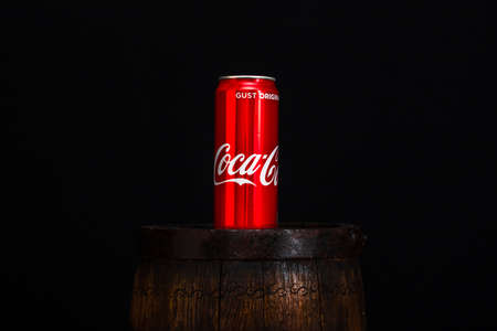 Can of Coca Cola on wooden barrel with dark background. Illustrative editorial photo Bucharest, Romania, 2021のeditorial素材