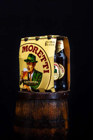 6 pack of Birra Moretti beer on wooden barrel with dark background. Illustrative editorial photo Bucharest, Romania, 2021のeditorial素材