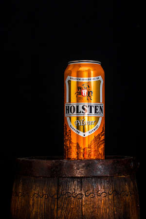 Can of Holsten beer on beer barrel with dark background. Illustrative editorial photo shot in Bucharest, Romania, 2021のeditorial素材