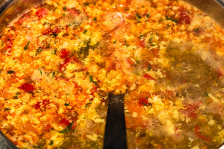 Preparation of soup with chicken and vegetables. Close up of boiling soup.
