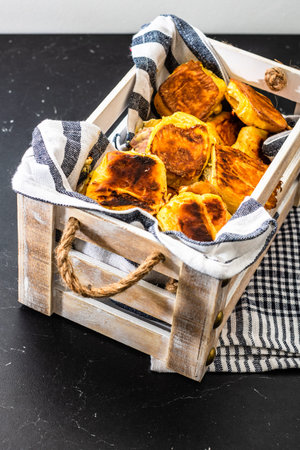 Freshly baked homemade ham and cheese puff pastry in a rustic crate.