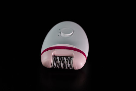 Hair removal concept, electric razor isolated on black background.