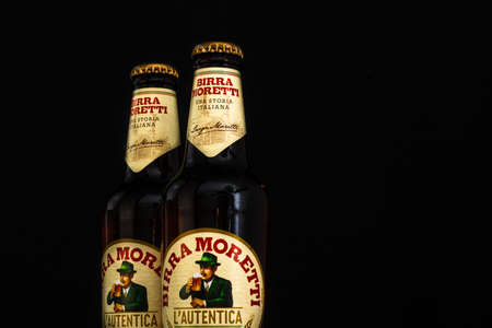 Bottle of Birra Moretti beer on wooden barrel with dark background. Illustrative editorial photo Bucharest, Romania, 2021のeditorial素材