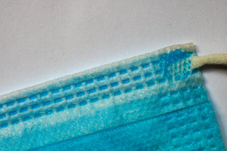 Macro selective focus on blue surgical mask. Texture of medical face mask background