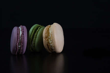 Colorful tasty macarons isolated on black background, french macarons dessertの写真素材