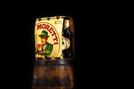 6 pack of Birra Moretti beer on wooden barrel with dark background. Illustrative editorial photo Bucharest, Romania, 2021のeditorial素材