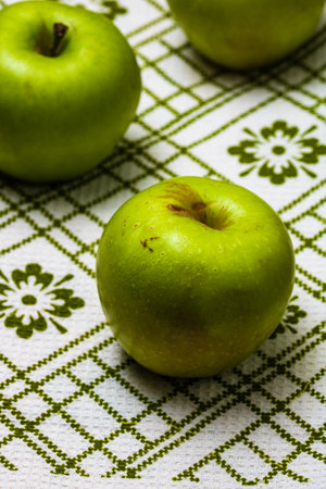 Ripe green apples on a rustic napkin on wooden table.の写真素材