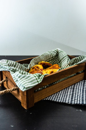 Freshly baked homemade ham and cheese puff pastry in a rustic crate.
