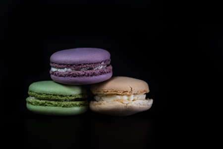 Colorful tasty macarons isolated on black background, french macarons dessertの写真素材