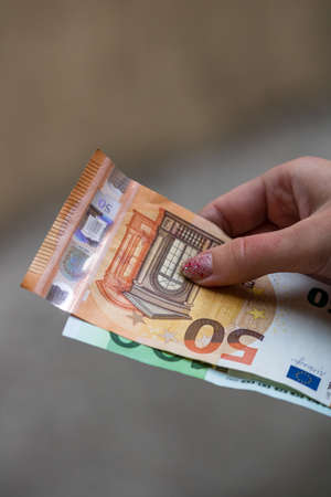 Selective focus on detail of EURO banknotes. Counting or giving EURO banknotes. World money concept, inflation and economy conceptの写真素材
