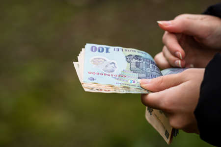 Selective focus on detail of LEI banknotes. Counting or giving Romanian LEI banknotes. World money concept, inflation and economy conceptの写真素材