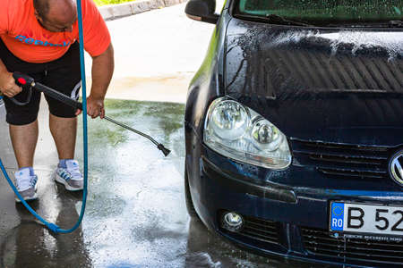 Washing and cleaning car in self service car wash station. Car washing using high pressure water in Bucharest, Romania, 2021のeditorial素材