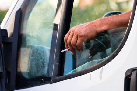 Driver holding hand on car door with open window, waiting in traffic concept close up. Bucharest, Romania, 2021のeditorial素材