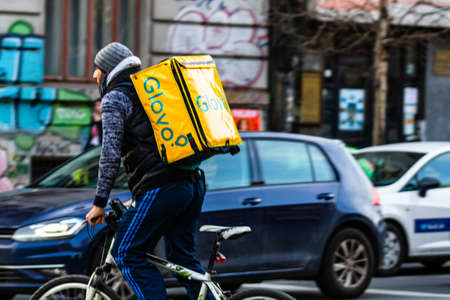 A Glovo food delivery courier on a bike. Restaurants are closed and only deliveries are allowed during the state of emergency due to coronavirus COVID-19 outbreak in Bucharest, Romania, 2020のeditorial素材