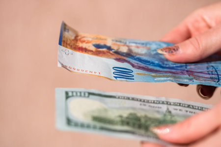 Detail of 100 USD banknotes next to 100 CHF banknotes. Detail of United States Dollar and Swiss...
