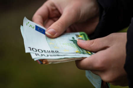 Selective focus on detail of EURO banknotes. Counting or giving EURO banknotes. World money concept, inflation and economy conceptの写真素材