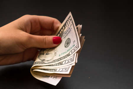 Selective focus on detail of USD banknotes. Counting or giving United States Dollars banknotes. World money concept, inflation and economy conceptの写真素材