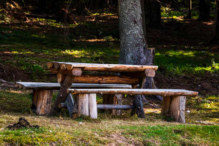 Wooden furniture table and bench in a mountain forestの写真素材